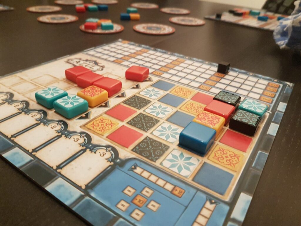 A game of Azul in progress with colourful tiles on the player boards
